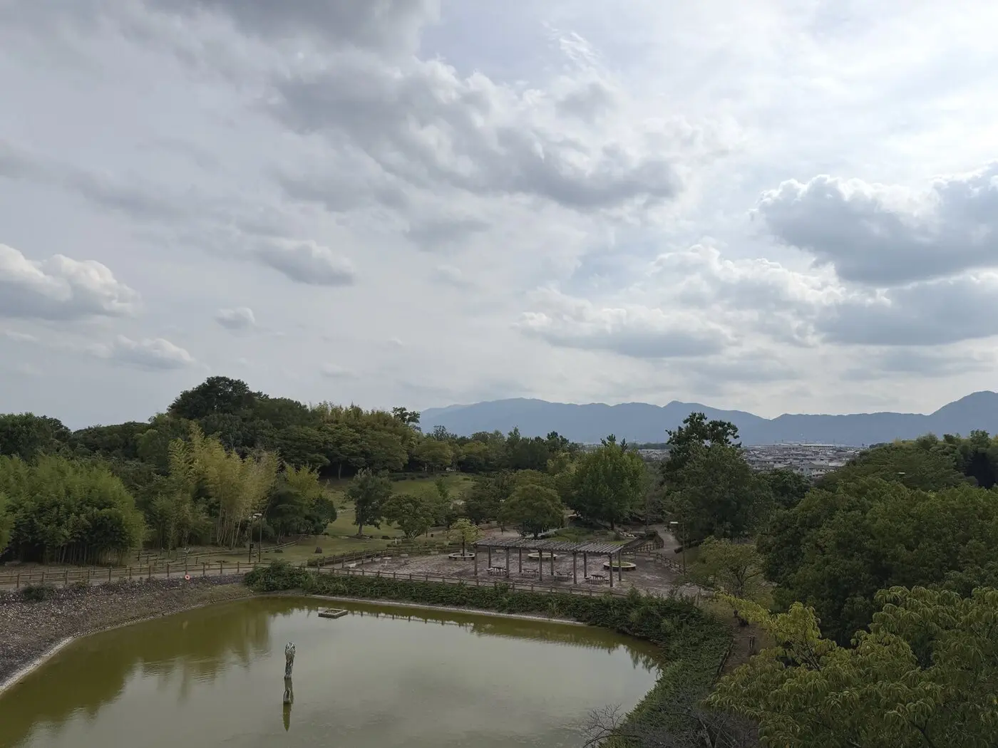 池と竹林、山並みを望む竹取公園の全景