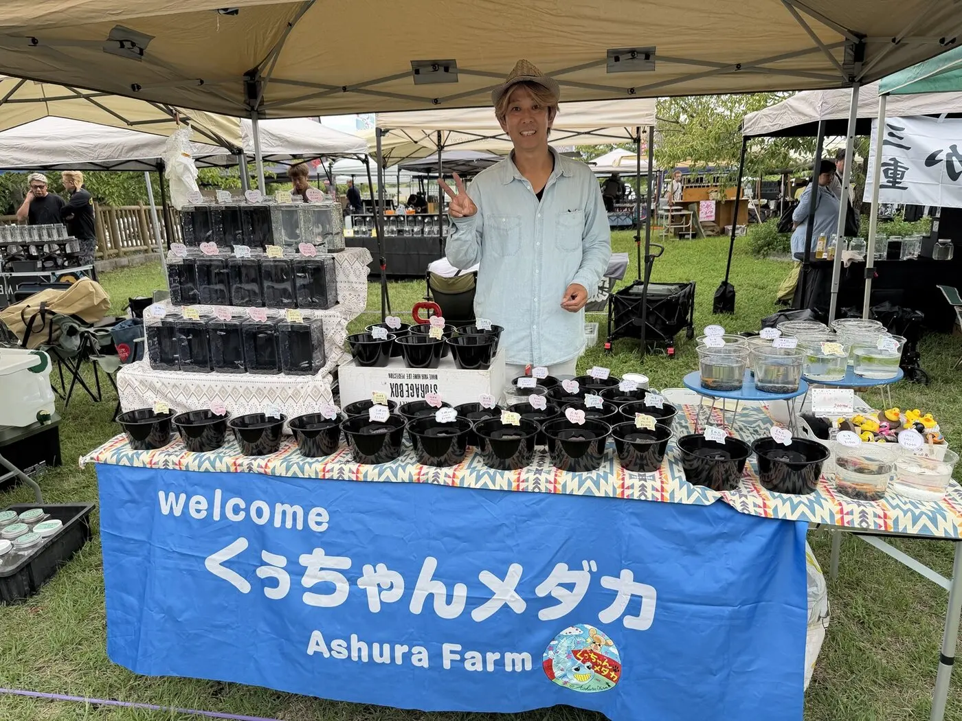 くうちゃんメダカのブースで笑顔を見せる出店者