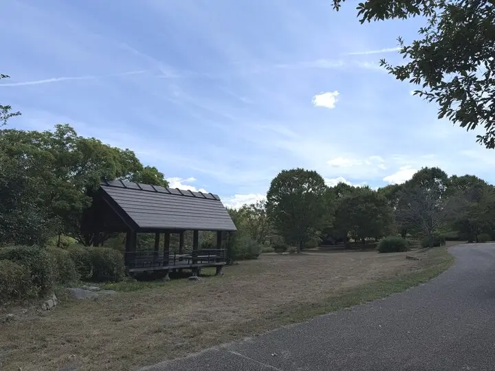 木々に囲まれた馬見丘陵公園の東屋と散策路